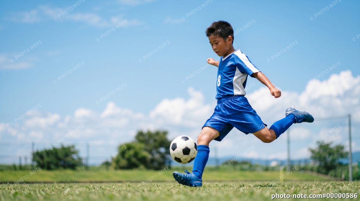 サッカーボールを蹴る少年