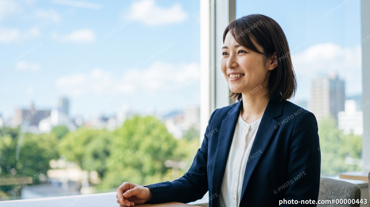 窓際の明るいオフィスで打合せや面接をするスーツ姿の女性会社員