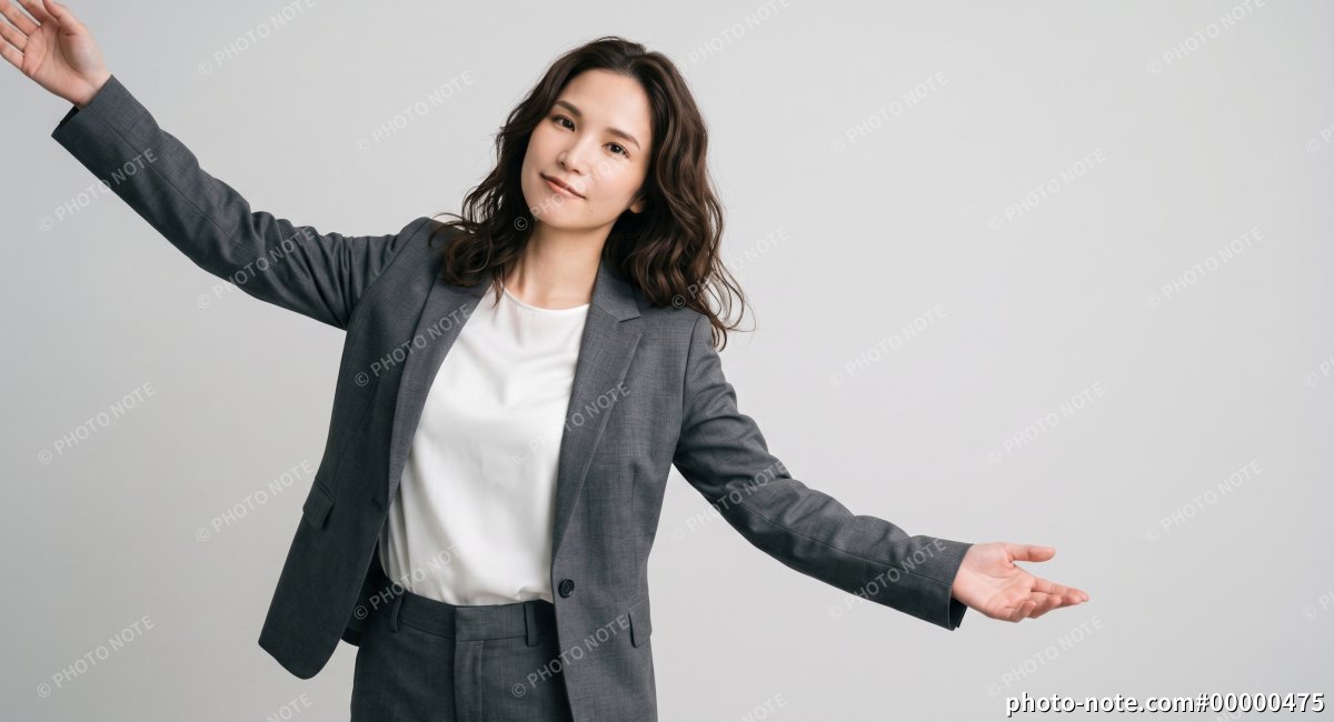 グレーのスーツを着て両腕を広げるビジネスパーソンの女性