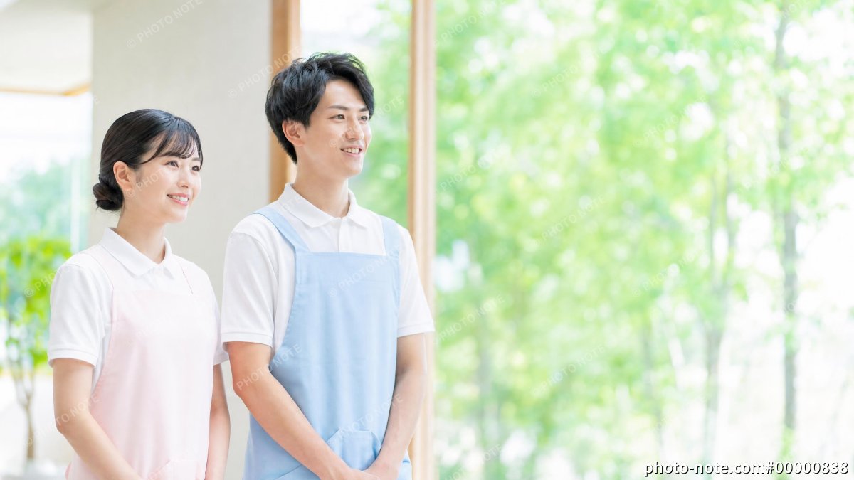 笑顔で並ぶ男女の介護士スタッフ、介護施設の採用イメージ