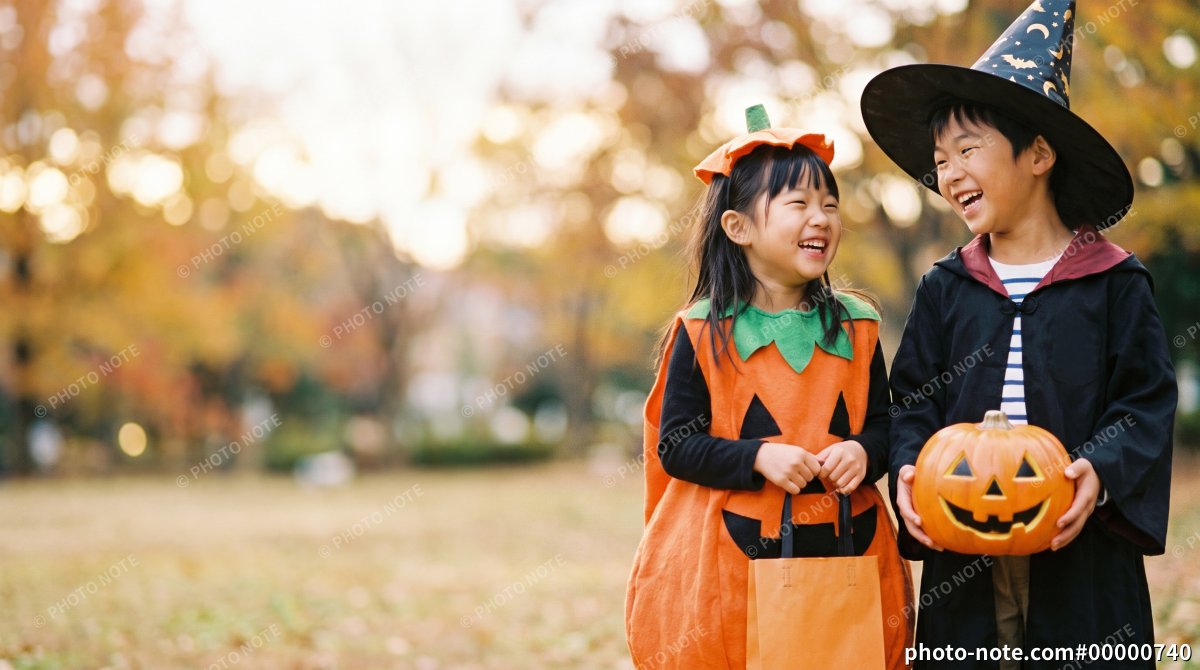 秋の公園でハロウィンのカボチャと魔法使いの仮装をして笑い合う子どもたち