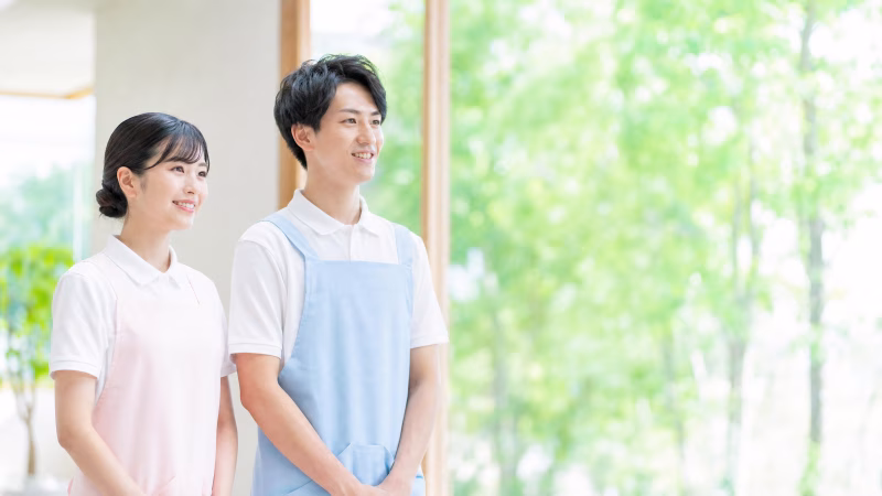 笑顔で並ぶ男女の介護士スタッフ、介護施設の採用イメージ