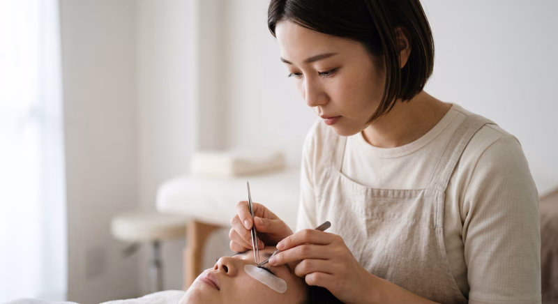 アイラッシュサロンで施術に集中する女性アイリスト
