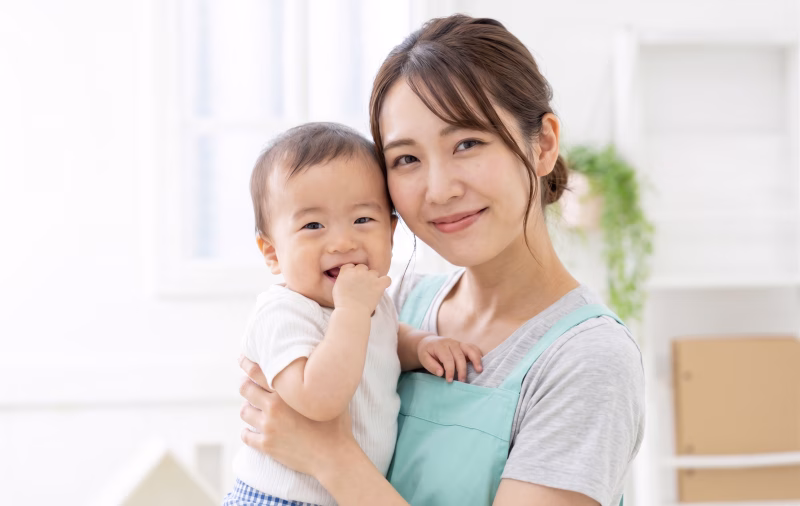 赤ちゃんを抱くベビーシッターの女性