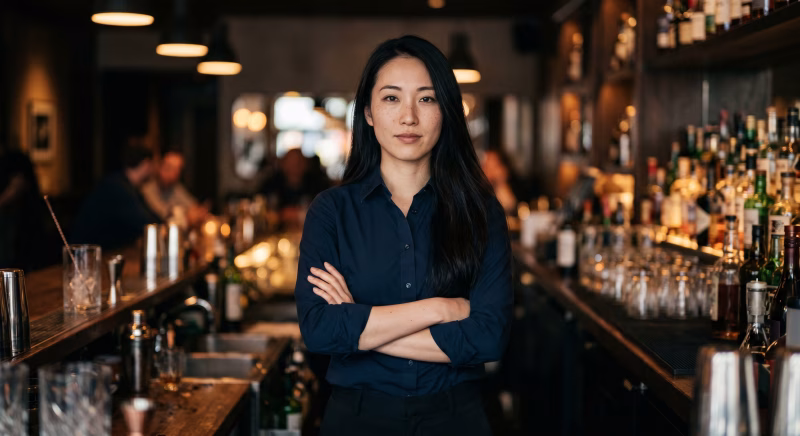 腕組みをするバーテンダーの女性