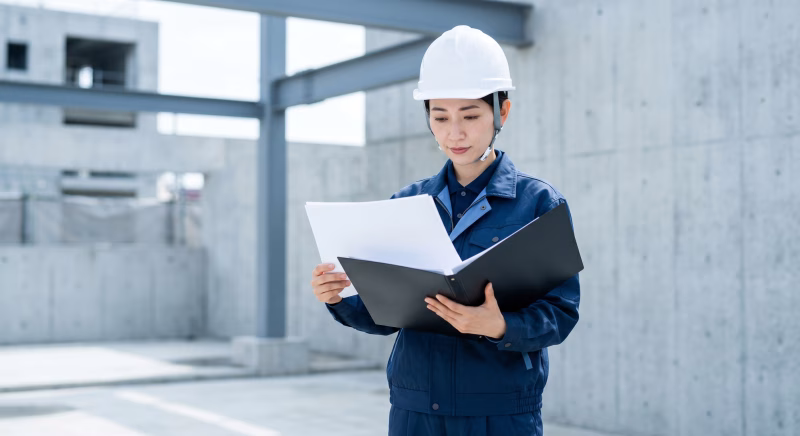 建設現場で書類を確認をする女性作業員