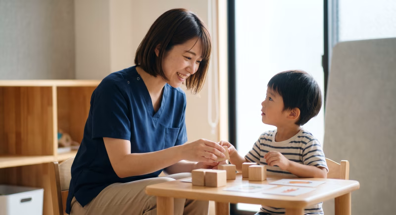 言語聴覚士の女性が子供に療育をしている様子