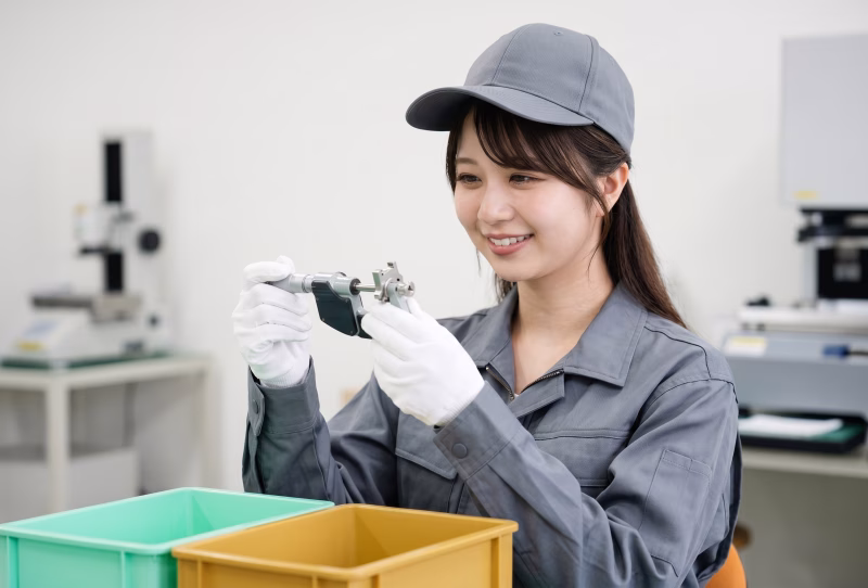 製造業の品質管理・検査作業を行う笑顔の女性スタッフ