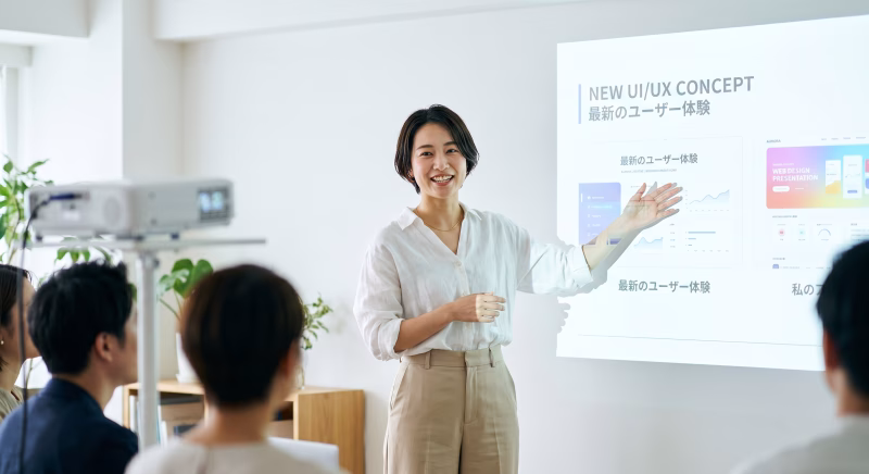 プロジェクターでUI UXのプレゼンテーションをする女性