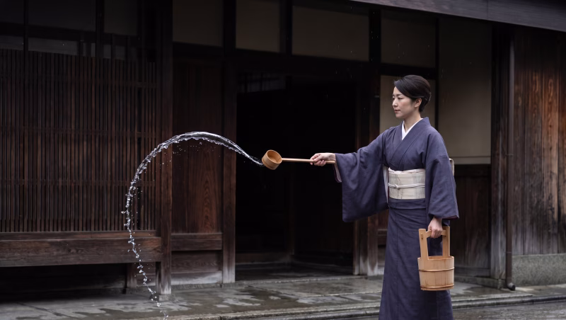 打ち水をする和服の女性
