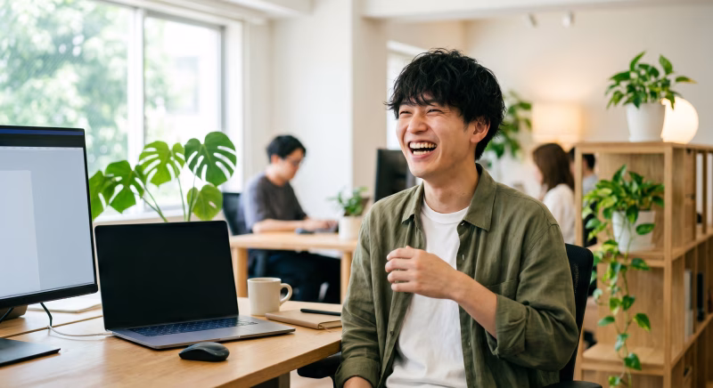 IT企業のオフィスで働く笑顔の男性クリエイター