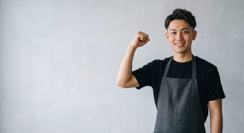 エプロンでガッツポーズをする男性スタッフ