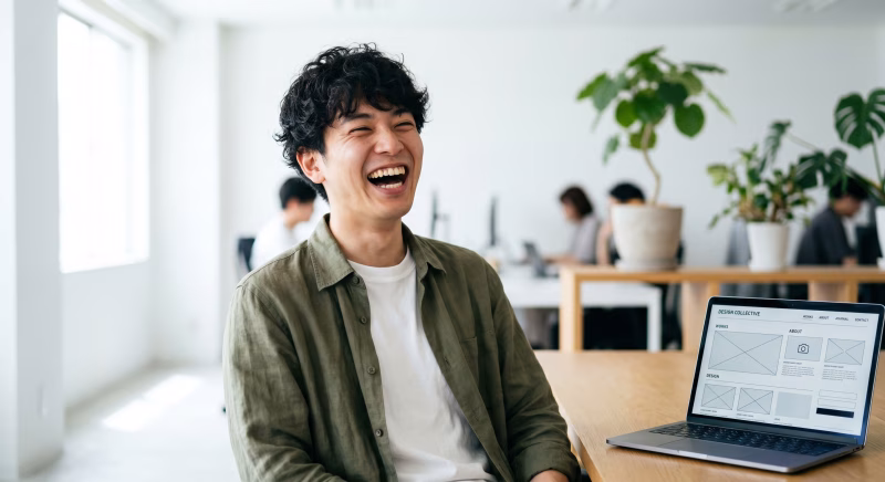 オフィスで働く笑顔のWebデザイナーの男性とワイヤーフレーム