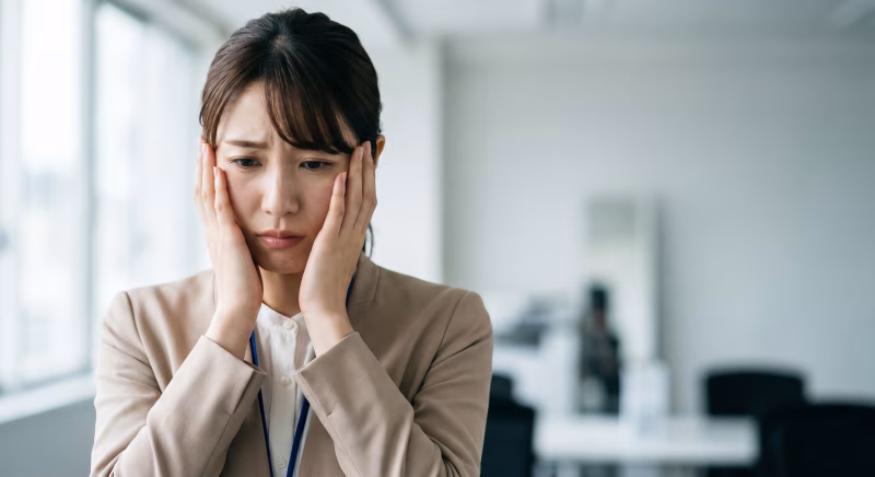 困った表情のスーツ姿の女性