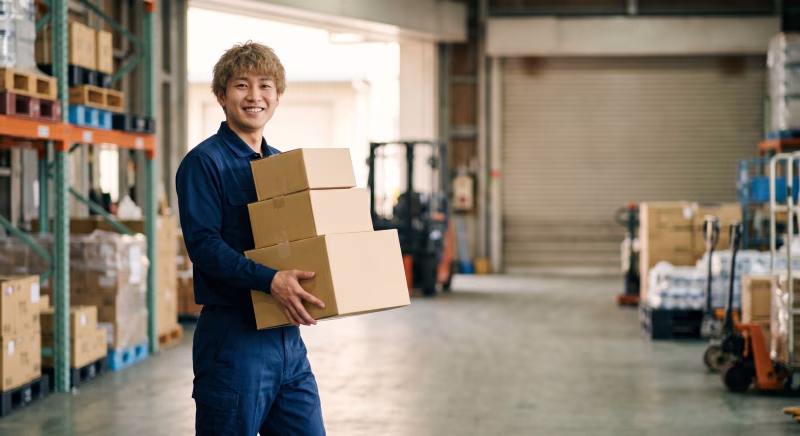 物流倉庫で荷物を運ぶ男性作業員