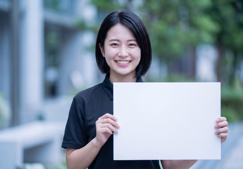 白いカードを掲げた女性