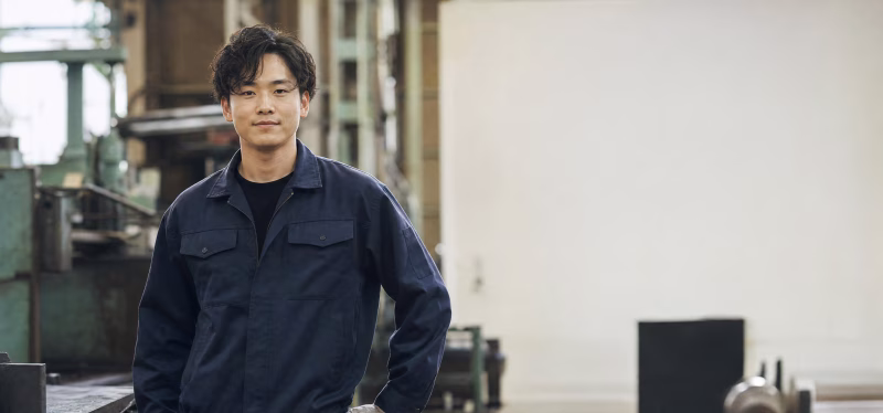 工場で立つ若い男性作業員