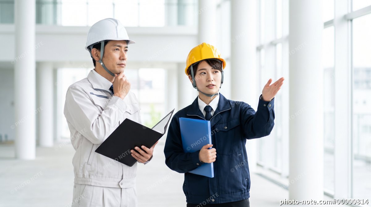 建設現場で説明をする女性作業員と確認する現場監督