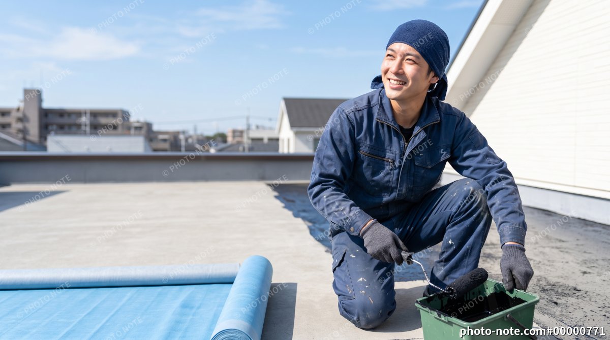 青空の下で屋上の防水工事を行う笑顔の男性作業員