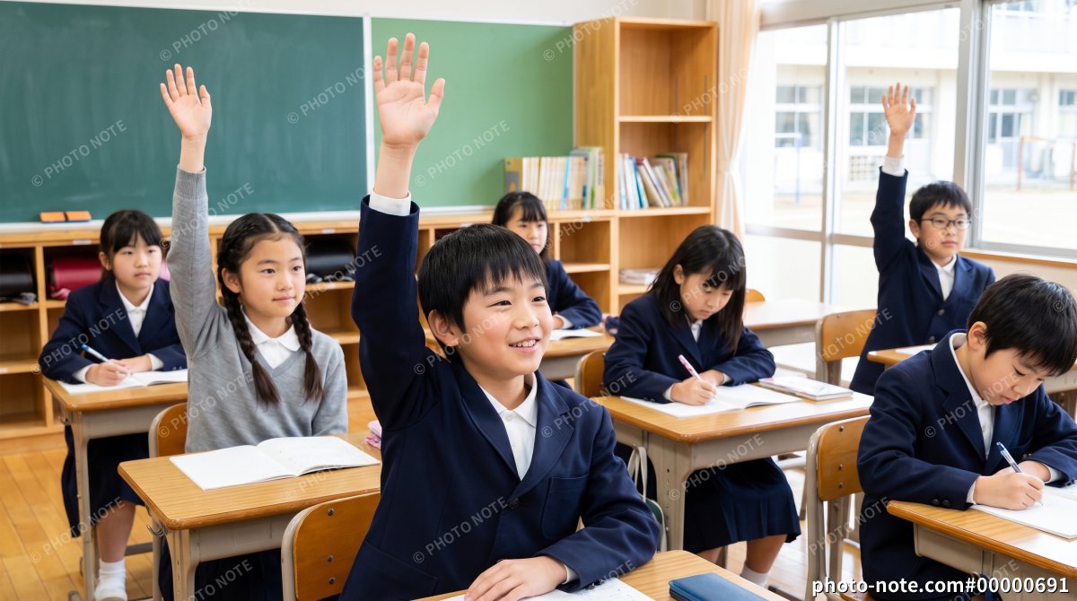 小学校の教室で挙手をする子ども