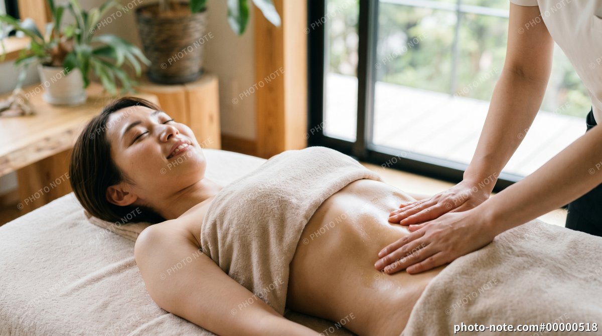 エステサロンで腹部のトリートメント施術を受ける女性