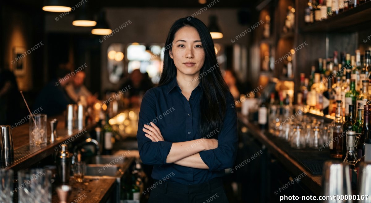 腕組みをするバーテンダーの女性