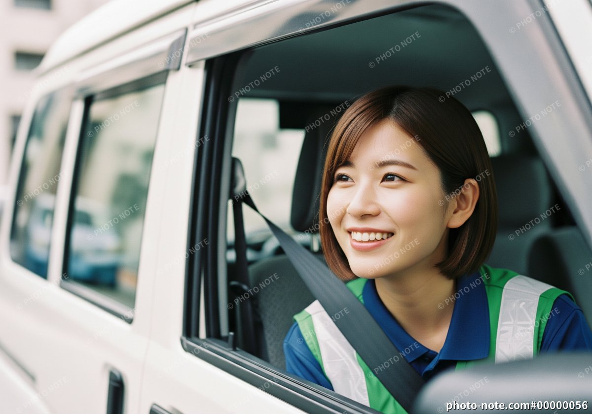 軽貨物トラックの運転席から笑顔を見せる女性ドライバー