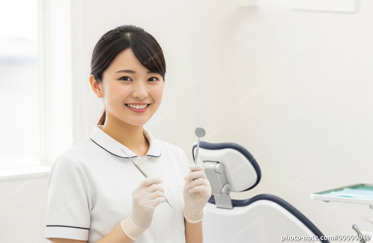 歯科用器具を手に持つ笑顔の歯科衛生士