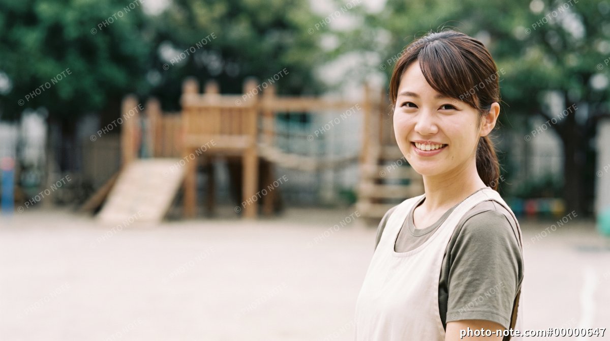園庭に立つ保育士の女性