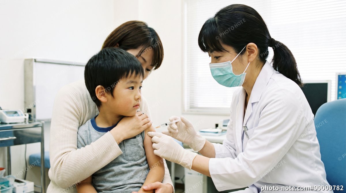 母親に付き添われて予防接種を受ける日本人の男の子