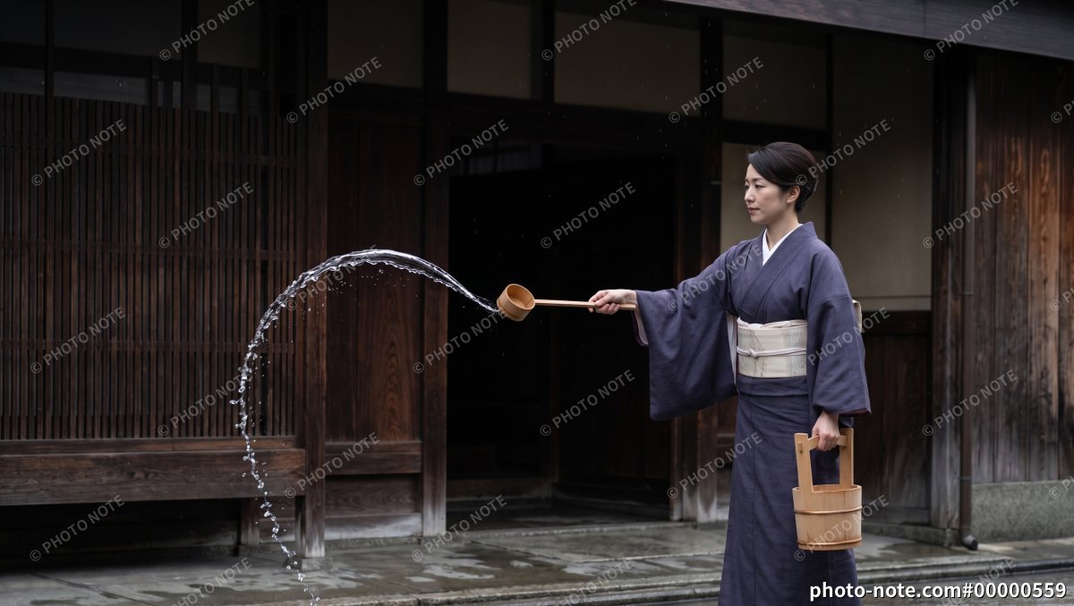 打ち水をする和服の女性