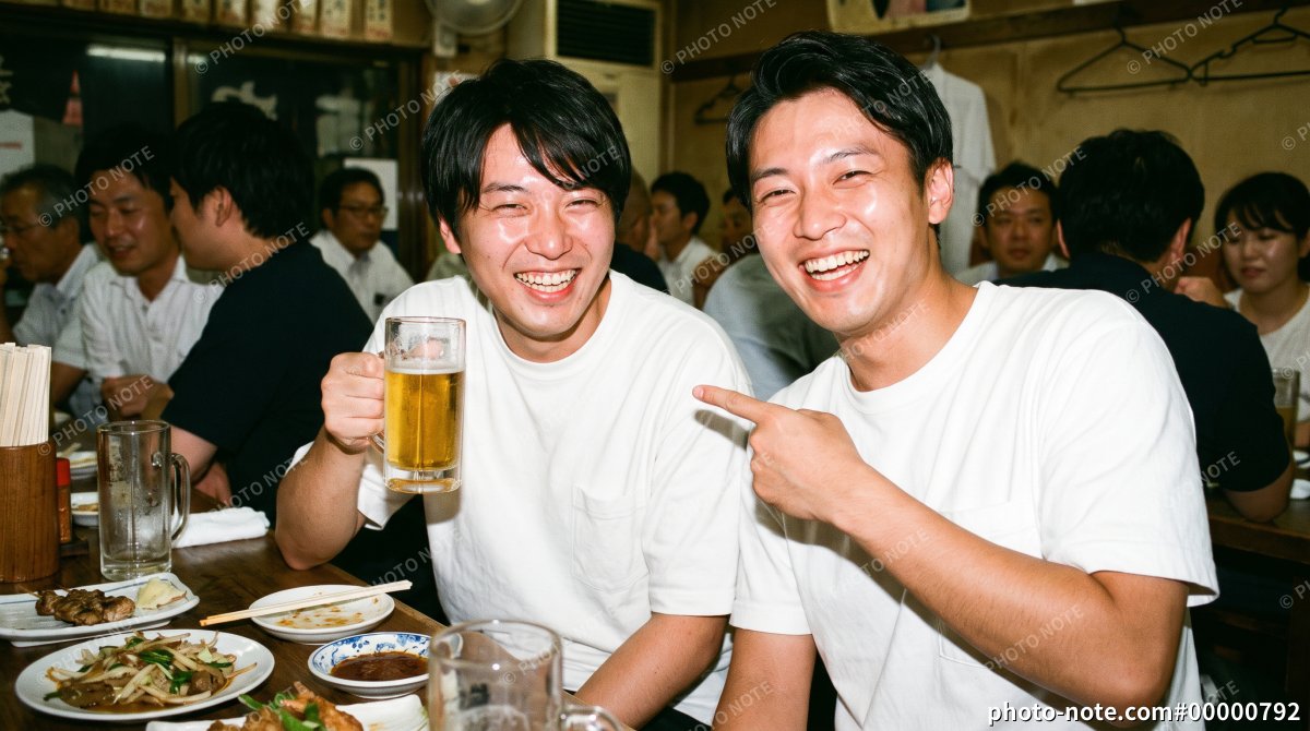 居酒屋でビールを手に笑顔を見せる日本人男性の友人同士