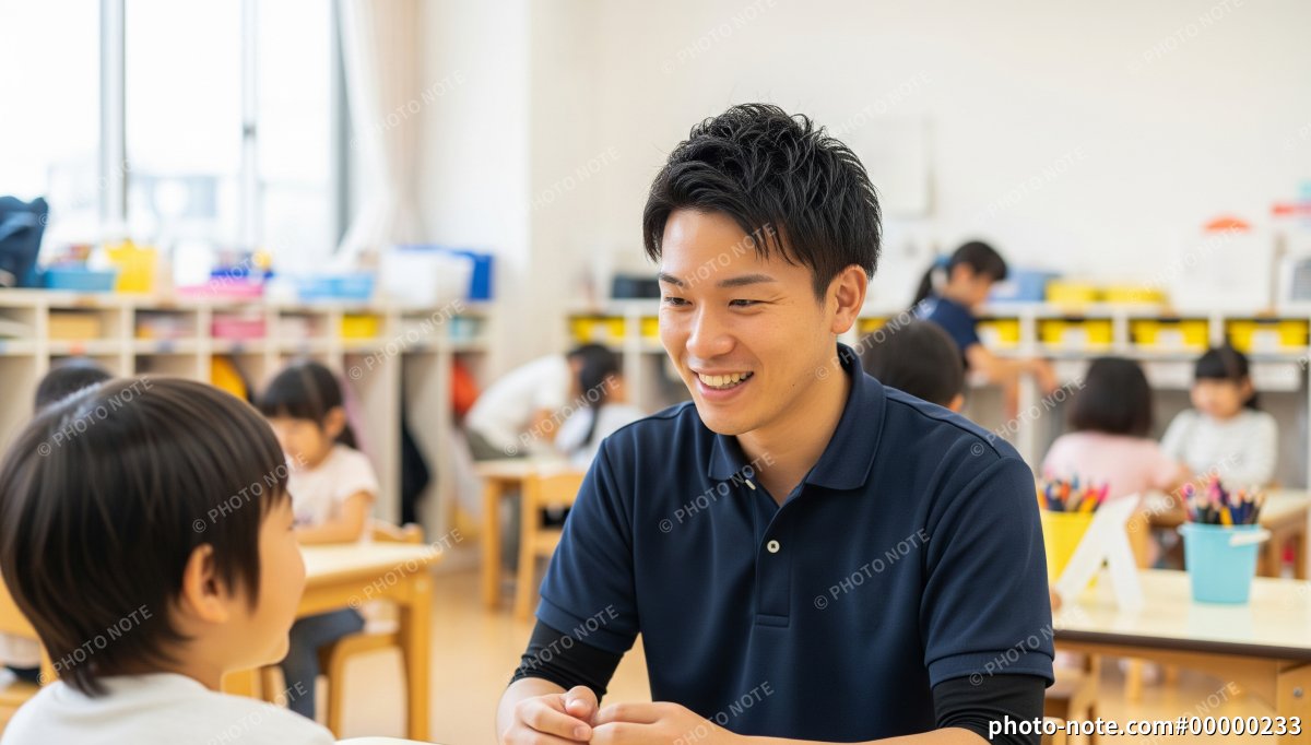笑顔で子どもと会話する保育士の男性