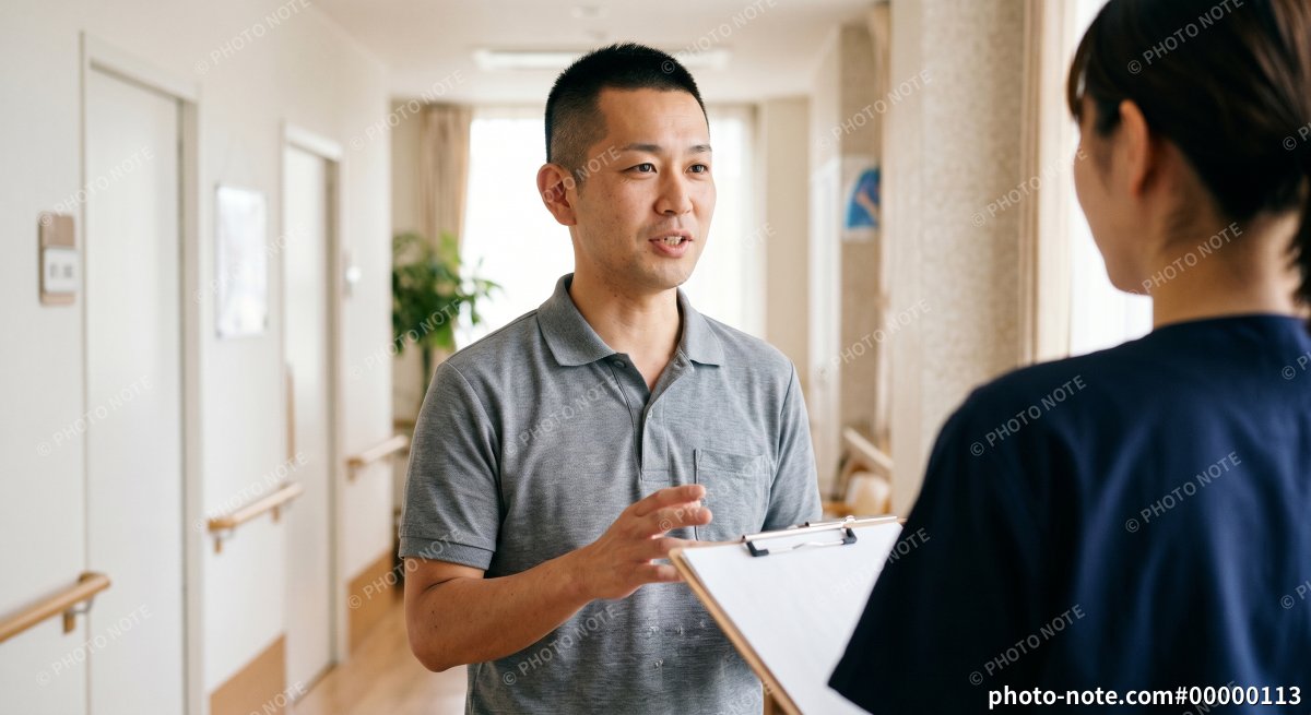 介護施設の廊下で打合せをするサービス責任者の男性