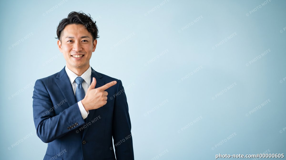 ポイントを指差す笑顔のスーツの男性