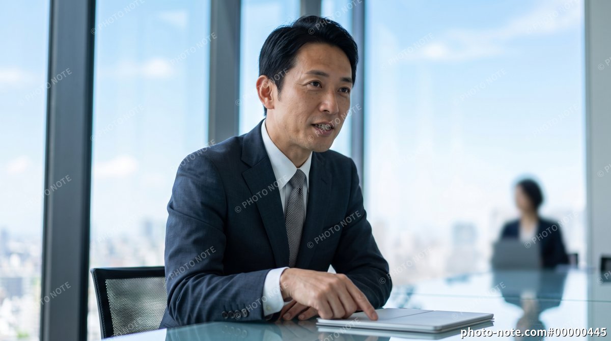 オフィスでの会議中に部下へ指示を出すミドル世代の管理職男性