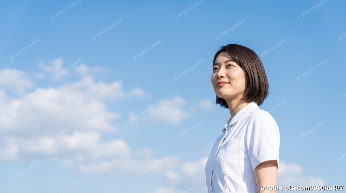 青空を見上げる白衣の看護師