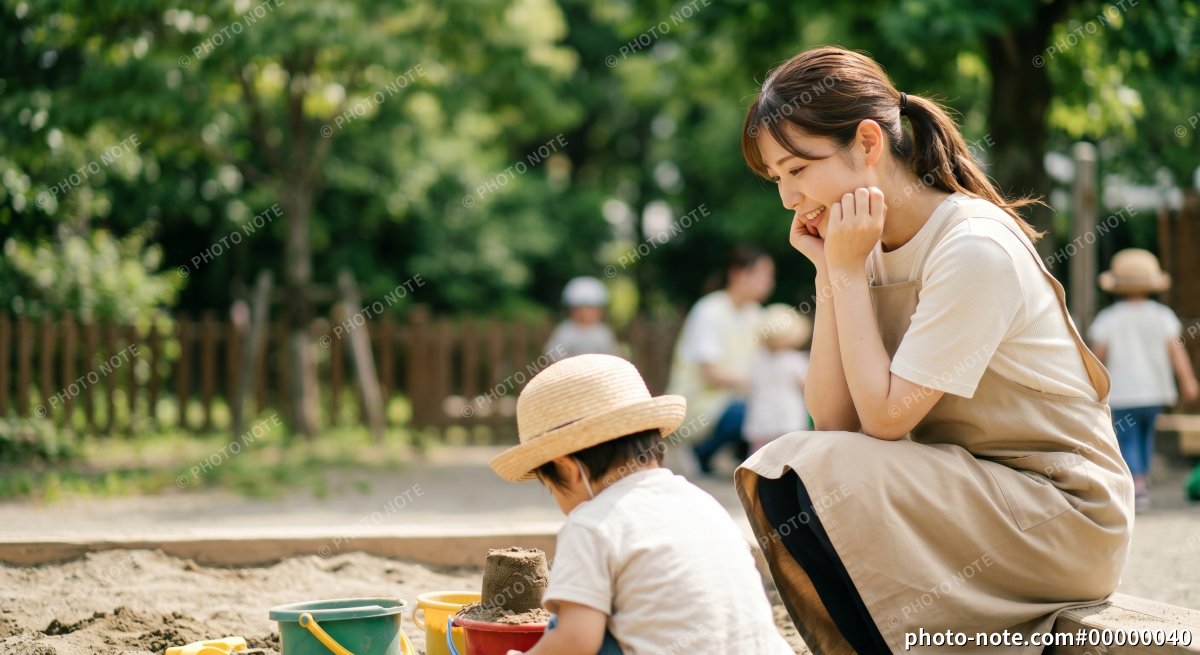 砂場で遊ぶ園児も見守る保育士の女性