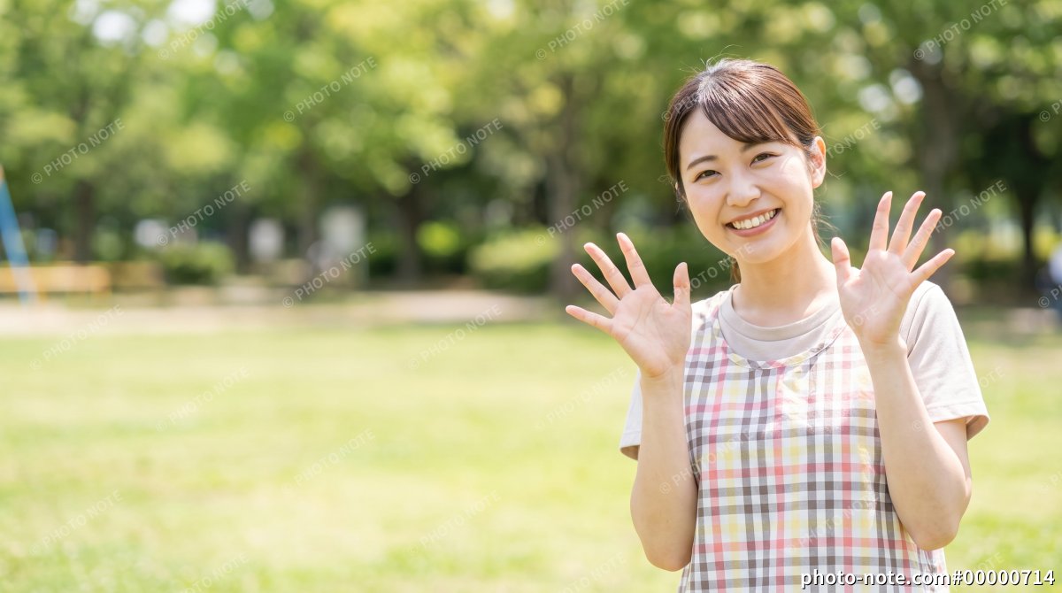 手を振る保育士の若い女性