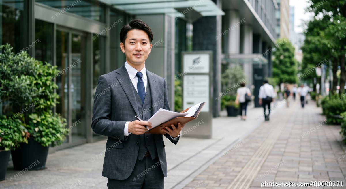 オフィスビルの前に立つ会計士・税理士のイメージ