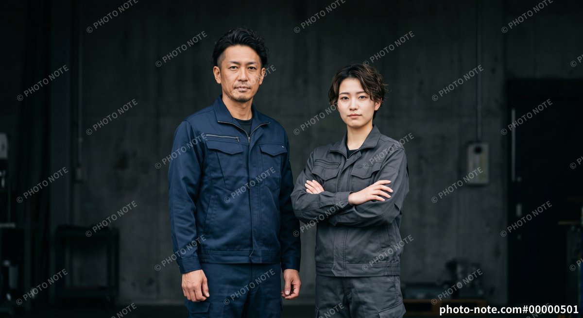製造業や建設業の現場で真剣な表情で並んで立つ男女の作業員