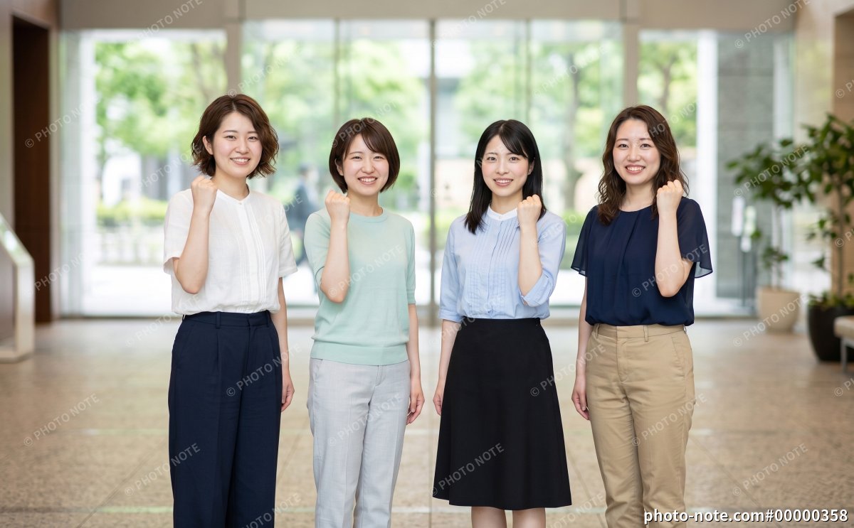 ガッツポーズをするオフィスカジュアルの女性