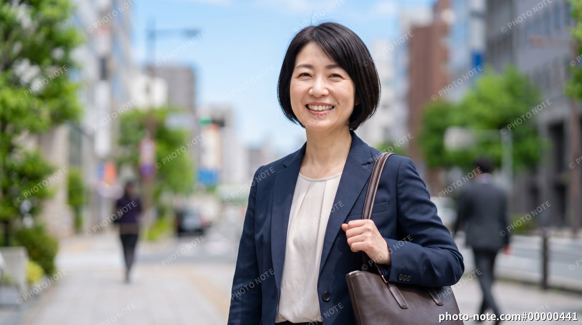 ビジネス街で外回り営業をする笑顔の40代女性会社員