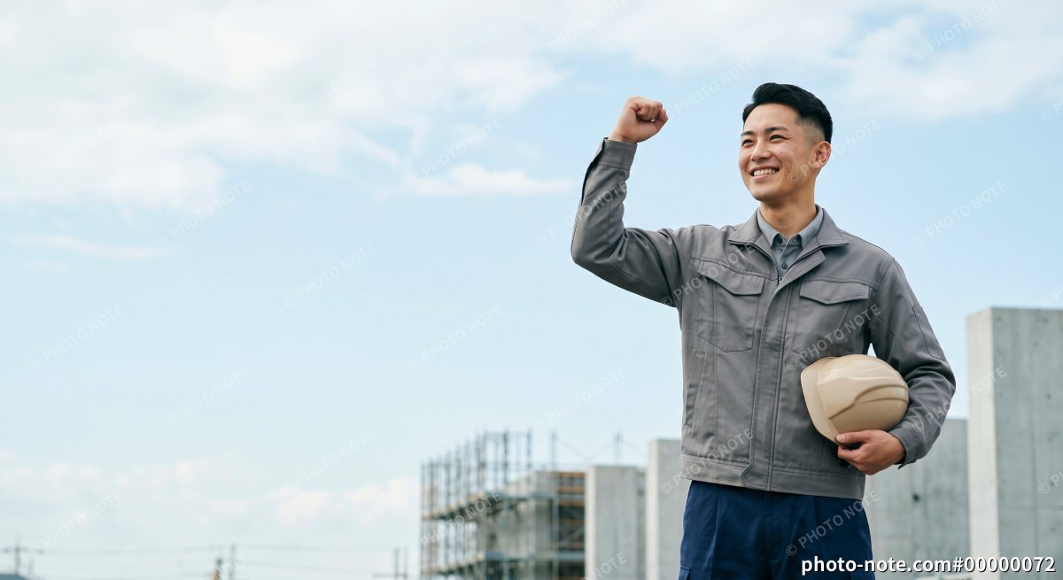 笑顔でガッツポーズをする施工管理の男性