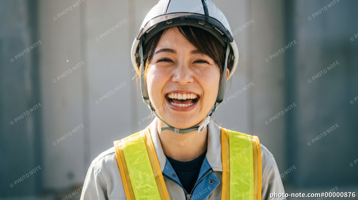 建設現場でヘルメットと反射ベストを着用しカメラを見つめる女性作業員