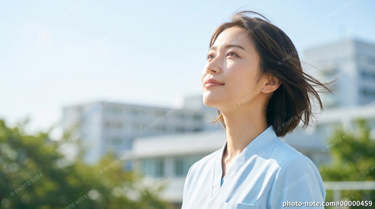 青空を見上げる笑顔の女性看護師