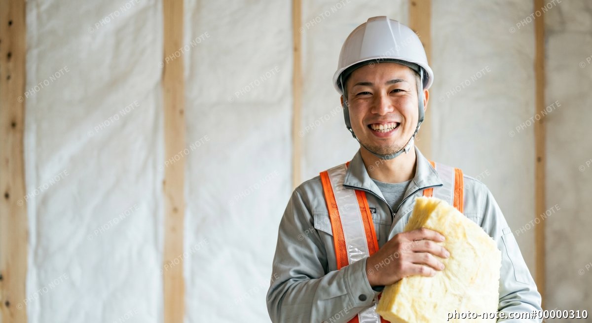 断熱工事を施工する笑顔の男性作業員