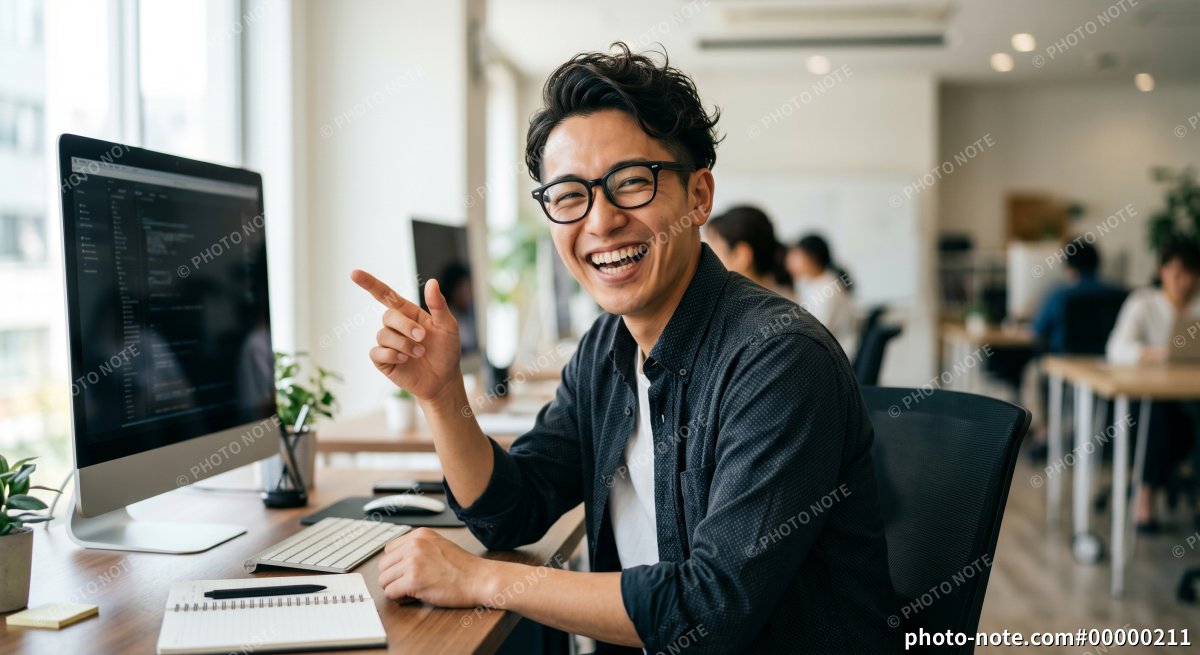 オフィスで働く笑顔のITエンジニアの男性