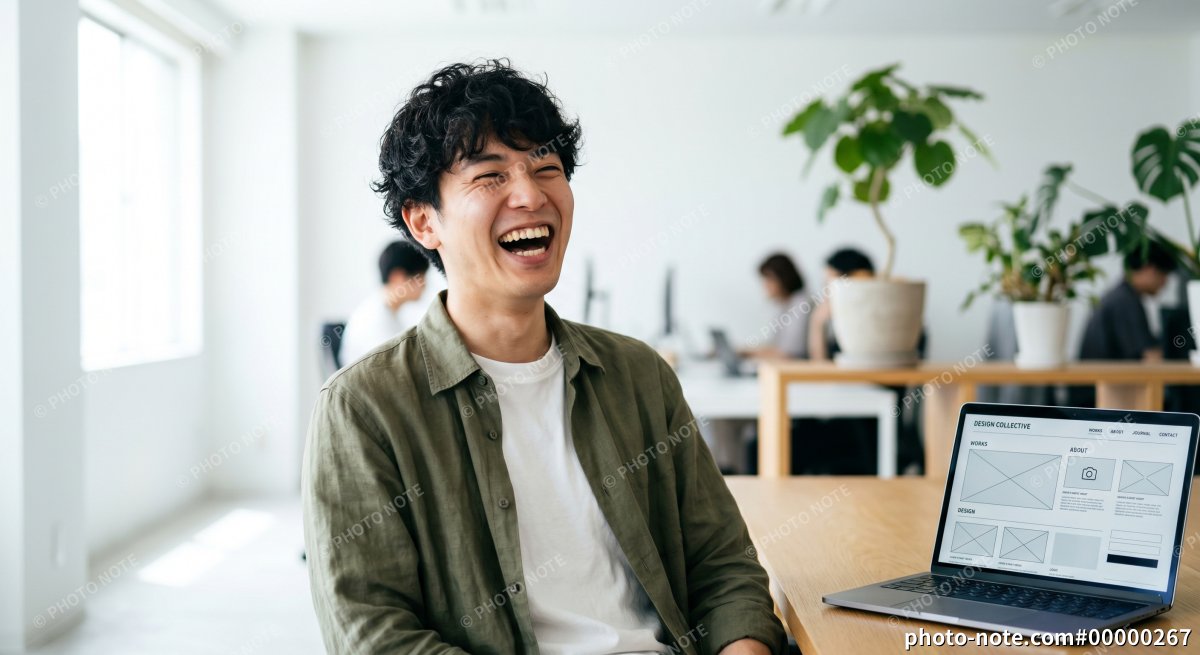 オフィスで働く笑顔のWebデザイナーの男性とワイヤーフレーム