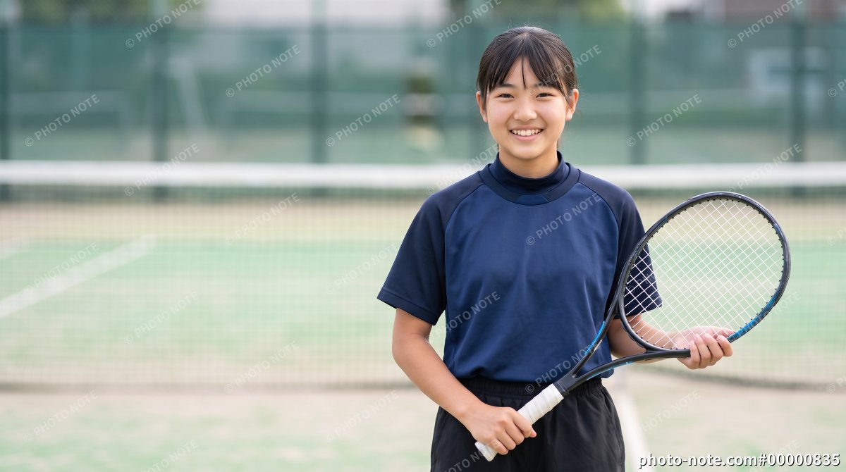 テニスコートでラケットを持つ10代の女子学生